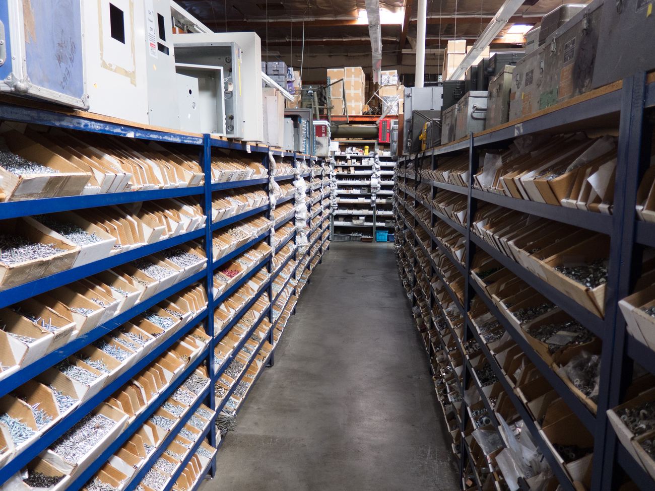Bins of screws, bolts and washers on racking down a trade counter aisle.